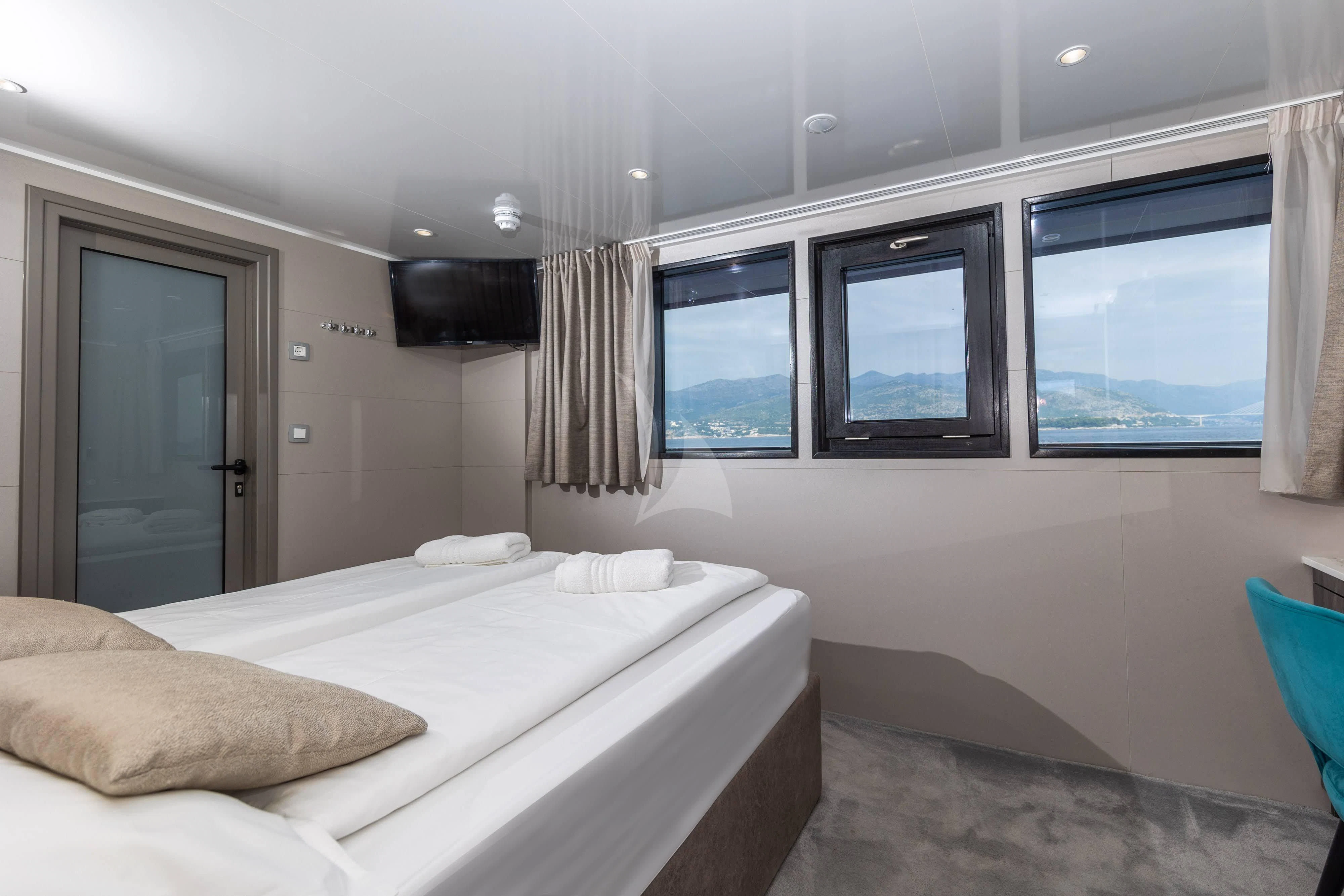 a bedroom with a bed and a window aboard LADY ELEGANZA Yacht for Sale