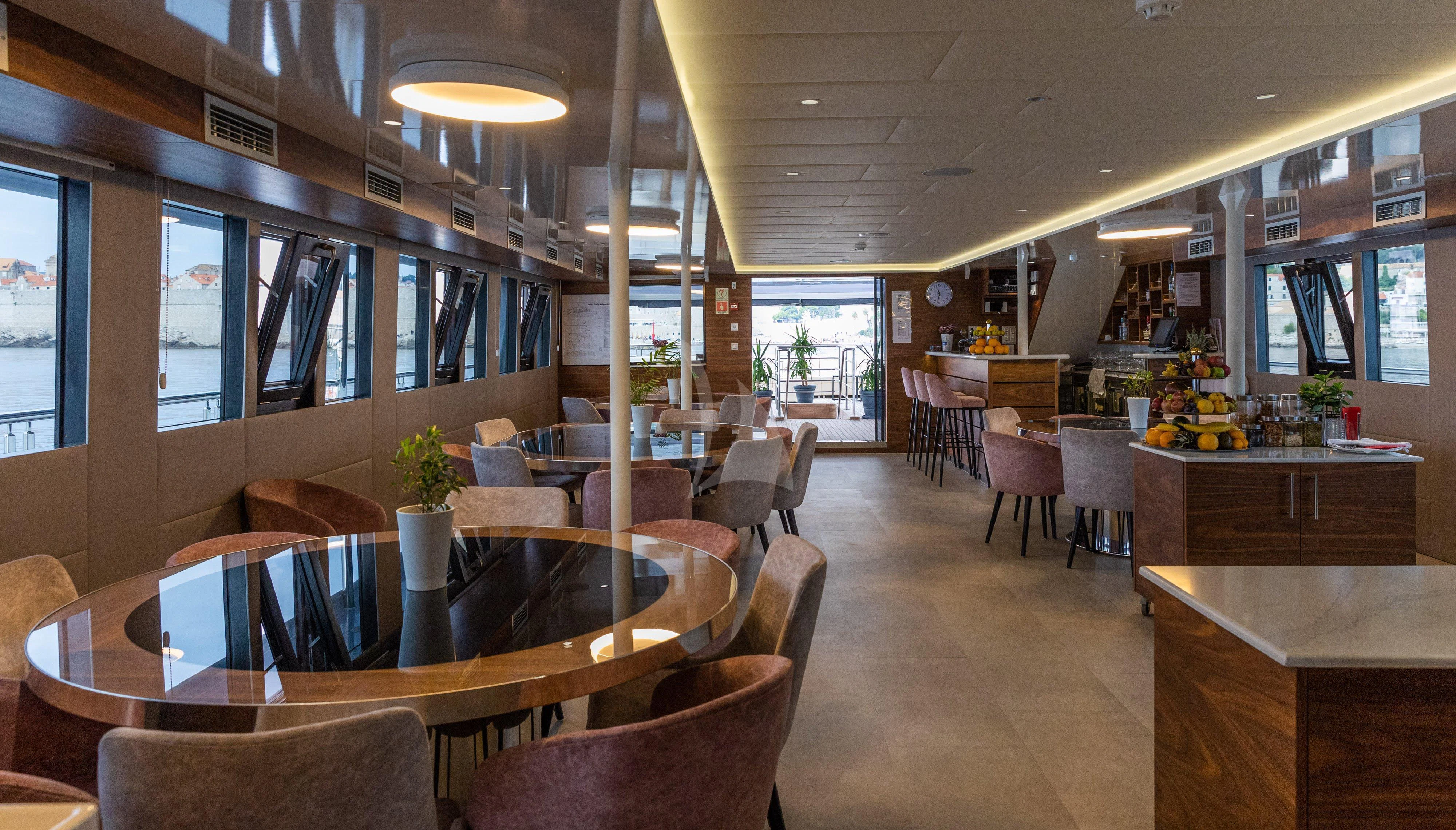 a restaurant with tables and chairs aboard LADY ELEGANZA Yacht for Sale