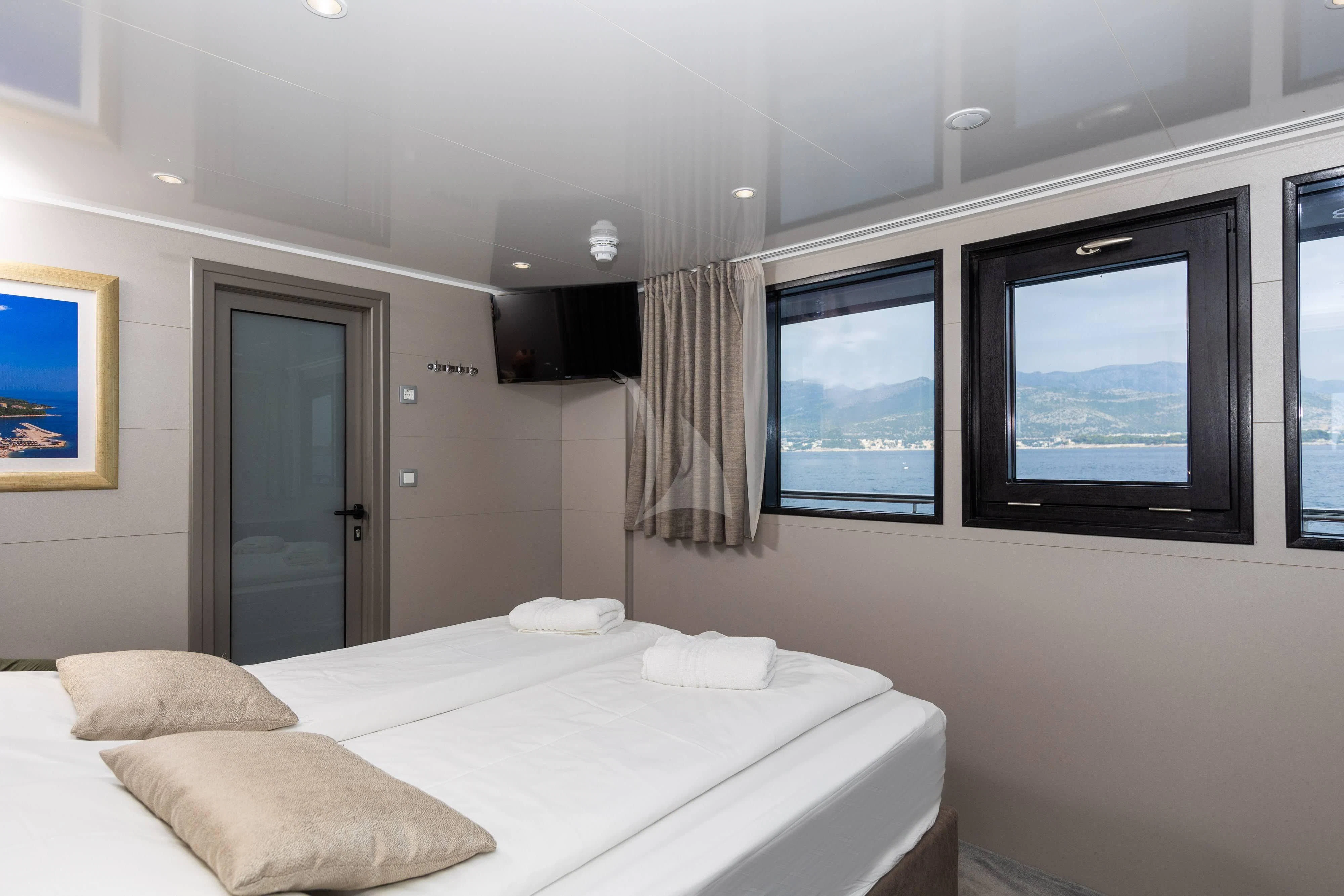 a bedroom with a large flat screen television and a bed aboard LADY ELEGANZA Yacht for Sale