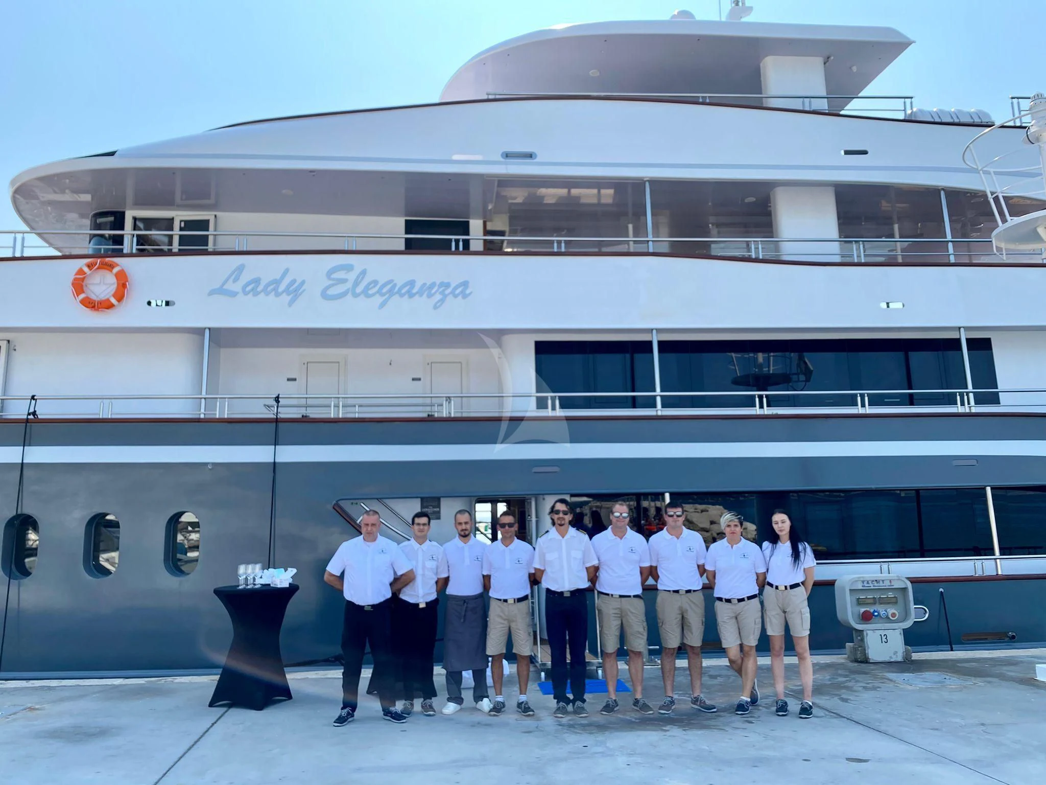 a group of people posing for a photo in front of a building aboard LADY ELEGANZA Yacht for Sale