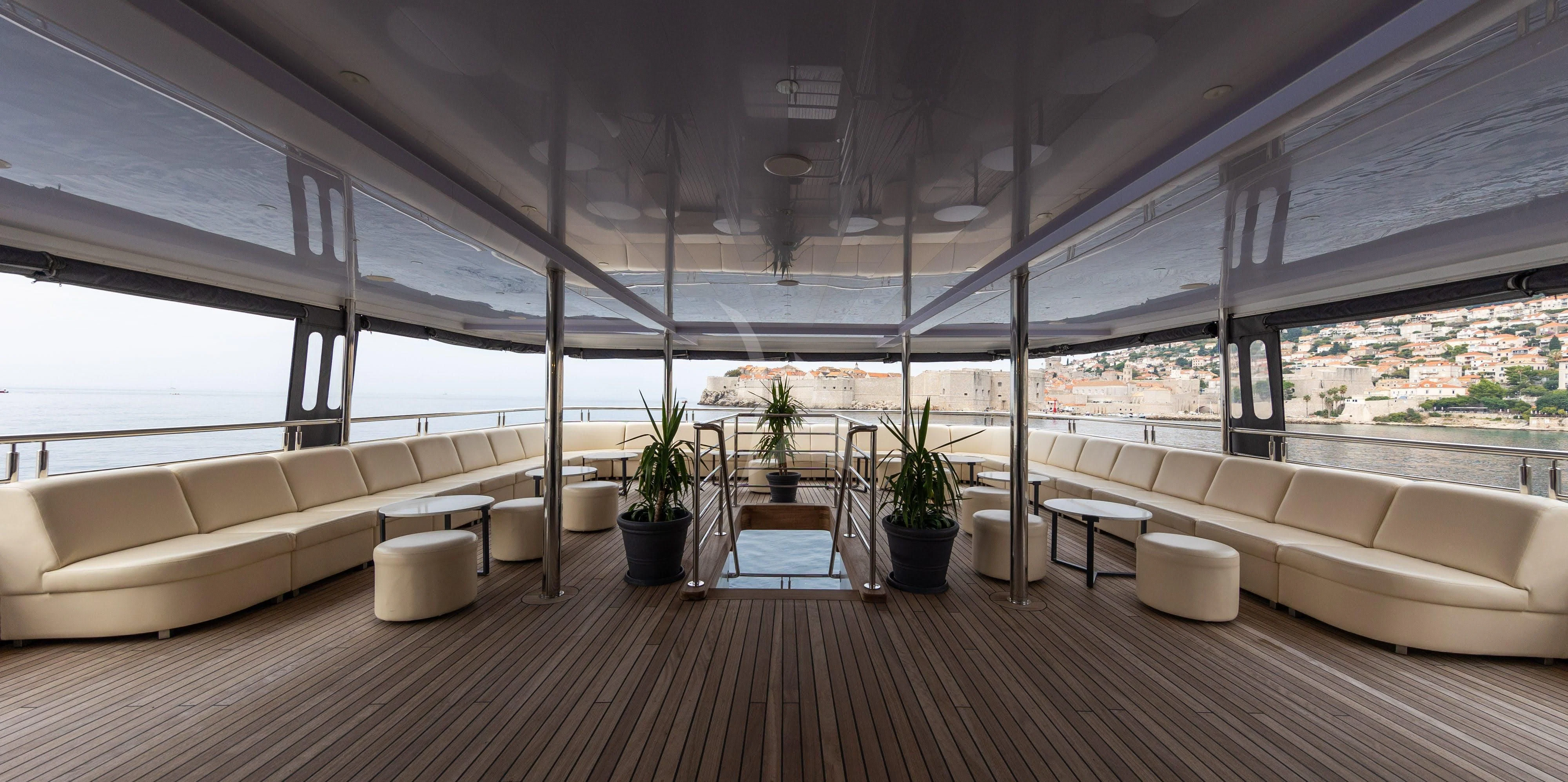 a room with a couch and a table and plants aboard LADY ELEGANZA Yacht for Sale
