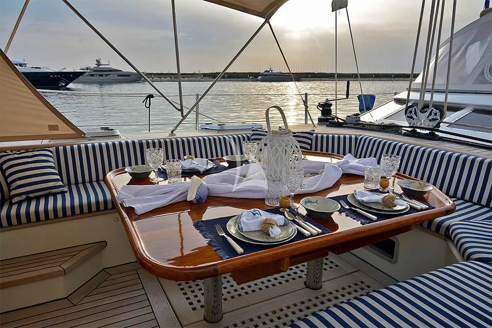 a table set with plates and glasses on a boat aboard WIND OF CHANGE Yacht for Charter