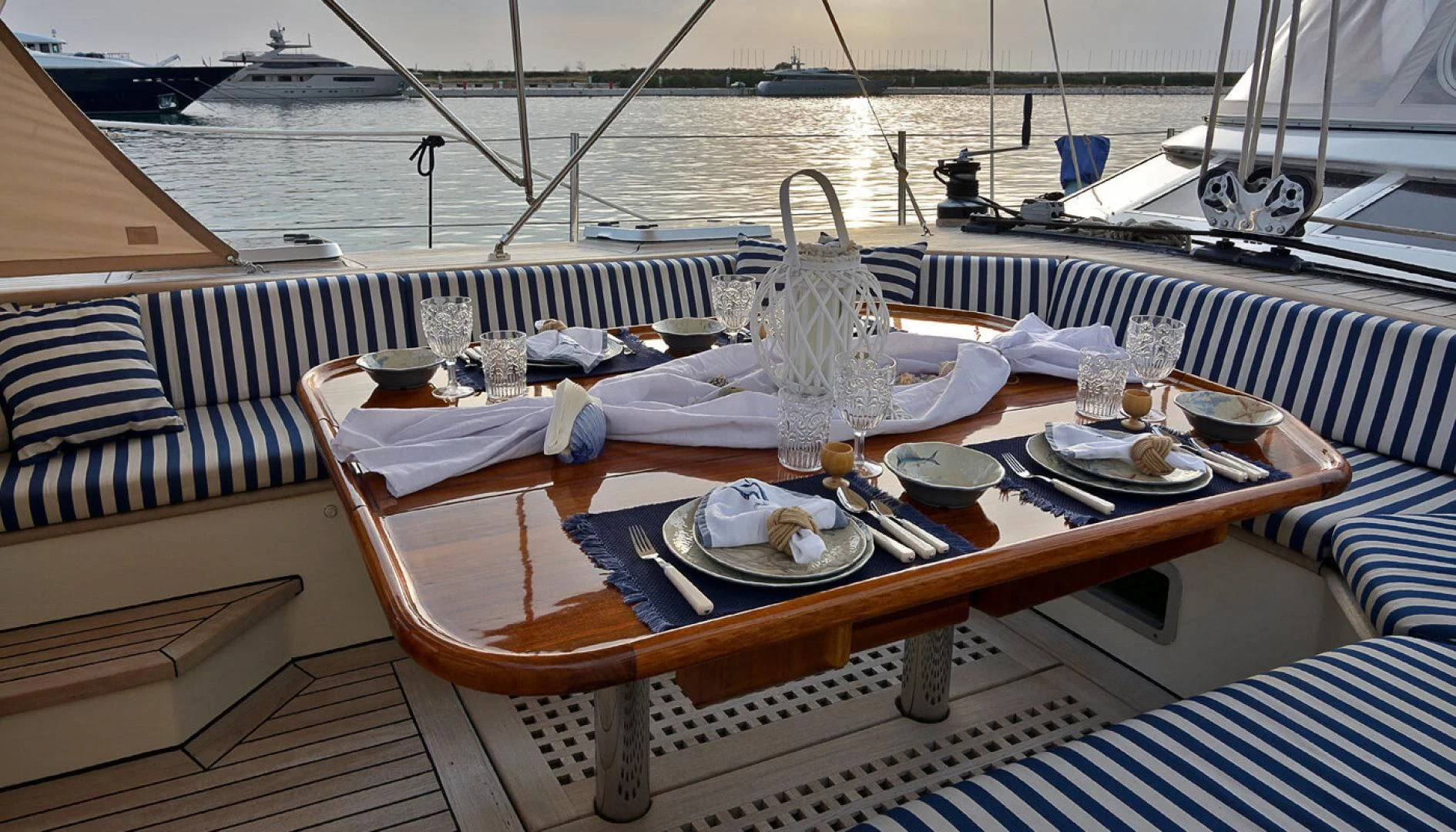 a table set with plates and glasses on a boat aboard WIND OF CHANGE Yacht for Charter