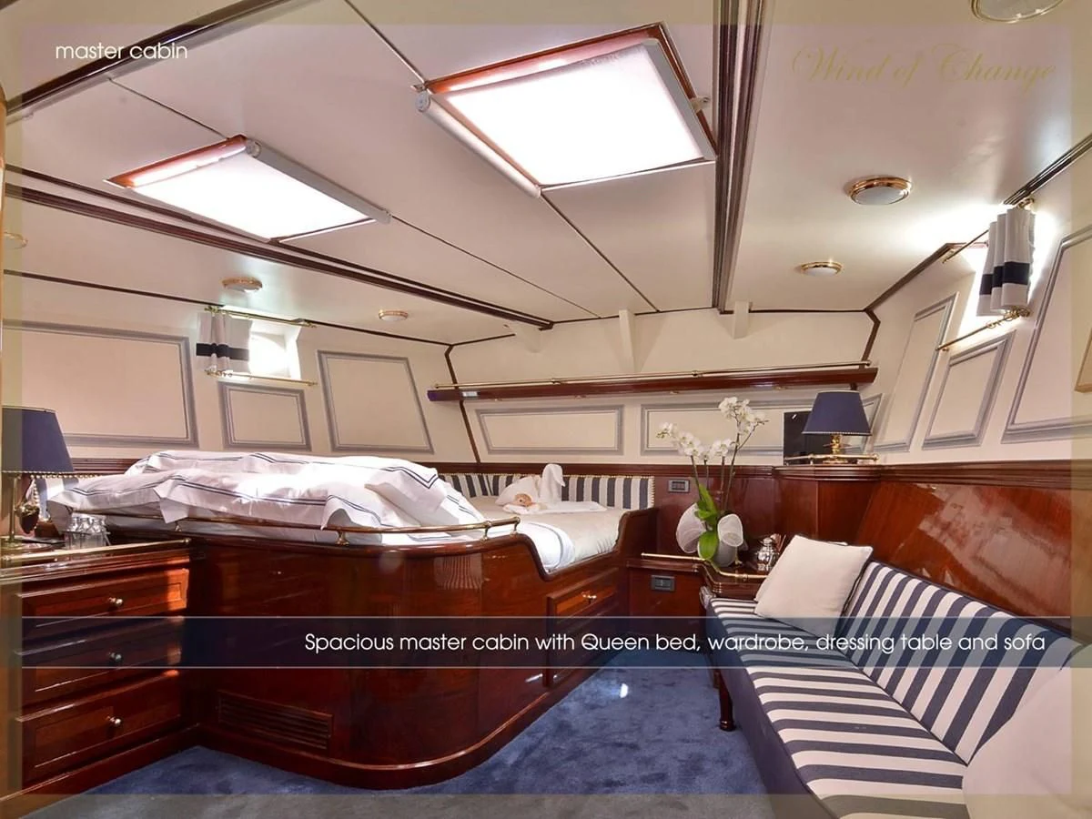 a room with a bed and a piano aboard WIND OF CHANGE Yacht for Charter