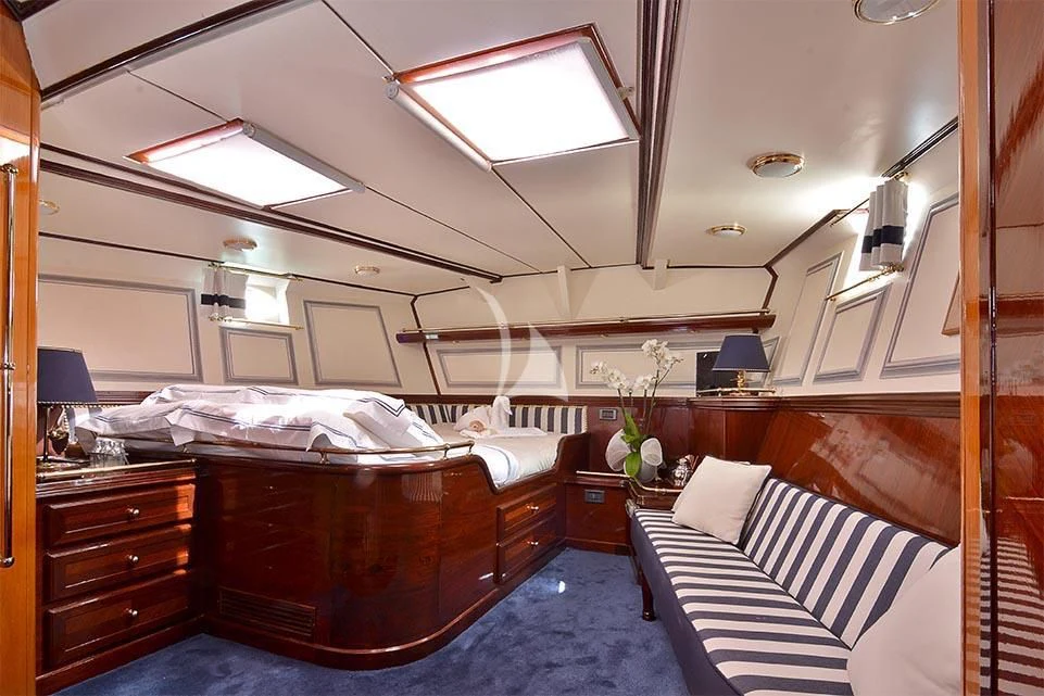 a bedroom with a bed and a desk aboard WIND OF CHANGE Yacht for Charter