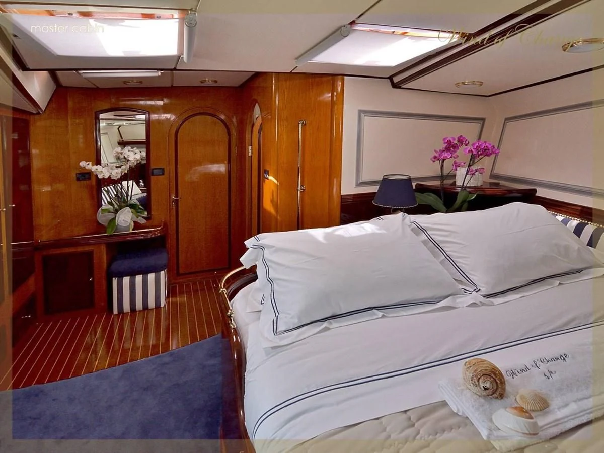 a room with a bed and a desk aboard WIND OF CHANGE Yacht for Charter