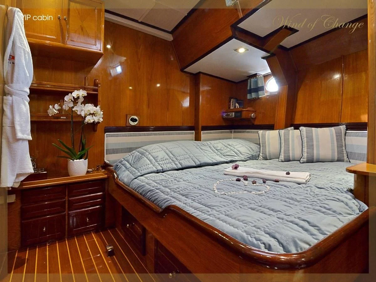 a bed with white sheets aboard WIND OF CHANGE Yacht for Charter