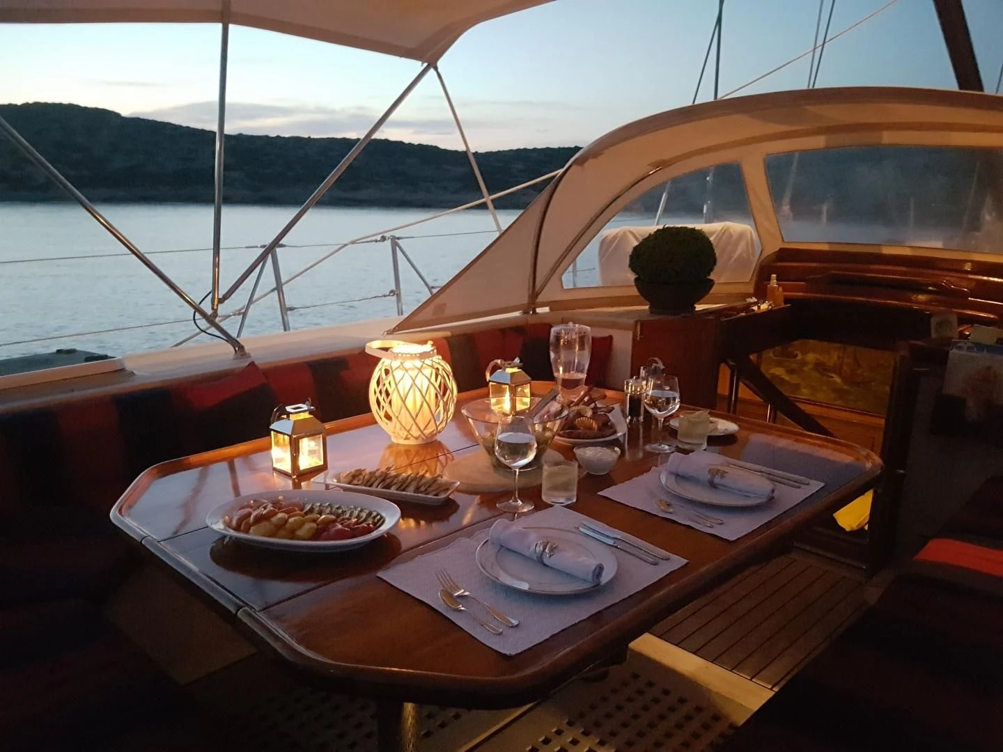 a table with food and wine glasses on it aboard WIND OF CHANGE Yacht for Charter