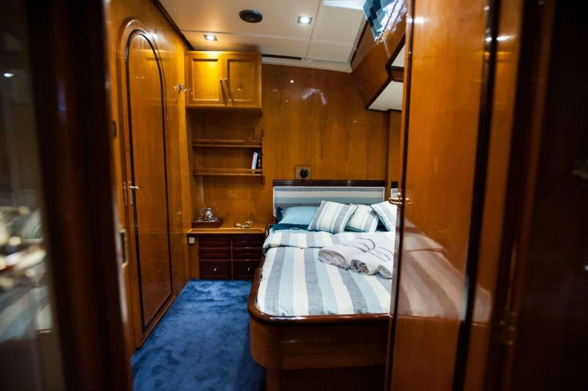 a bedroom with a bed and a bookcase aboard WIND OF CHANGE Yacht for Charter