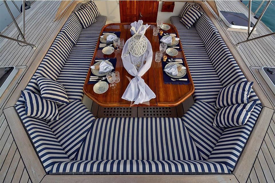 a dining table set with plates and silverware aboard WIND OF CHANGE Yacht for Charter