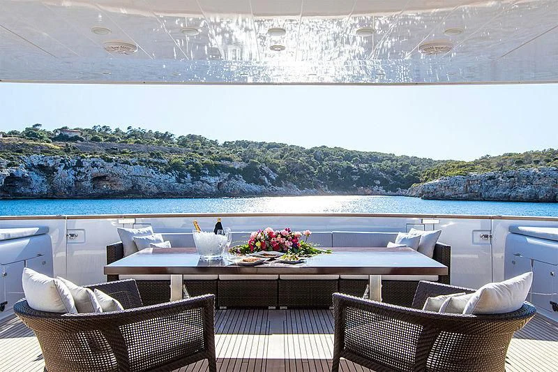 a table with chairs and a view of a city aboard ALWAYS BELIEVE Yacht for Sale