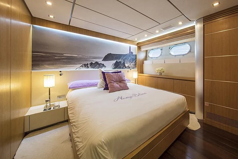 a bedroom with a bed and a lamp aboard ALWAYS BELIEVE Yacht for Sale