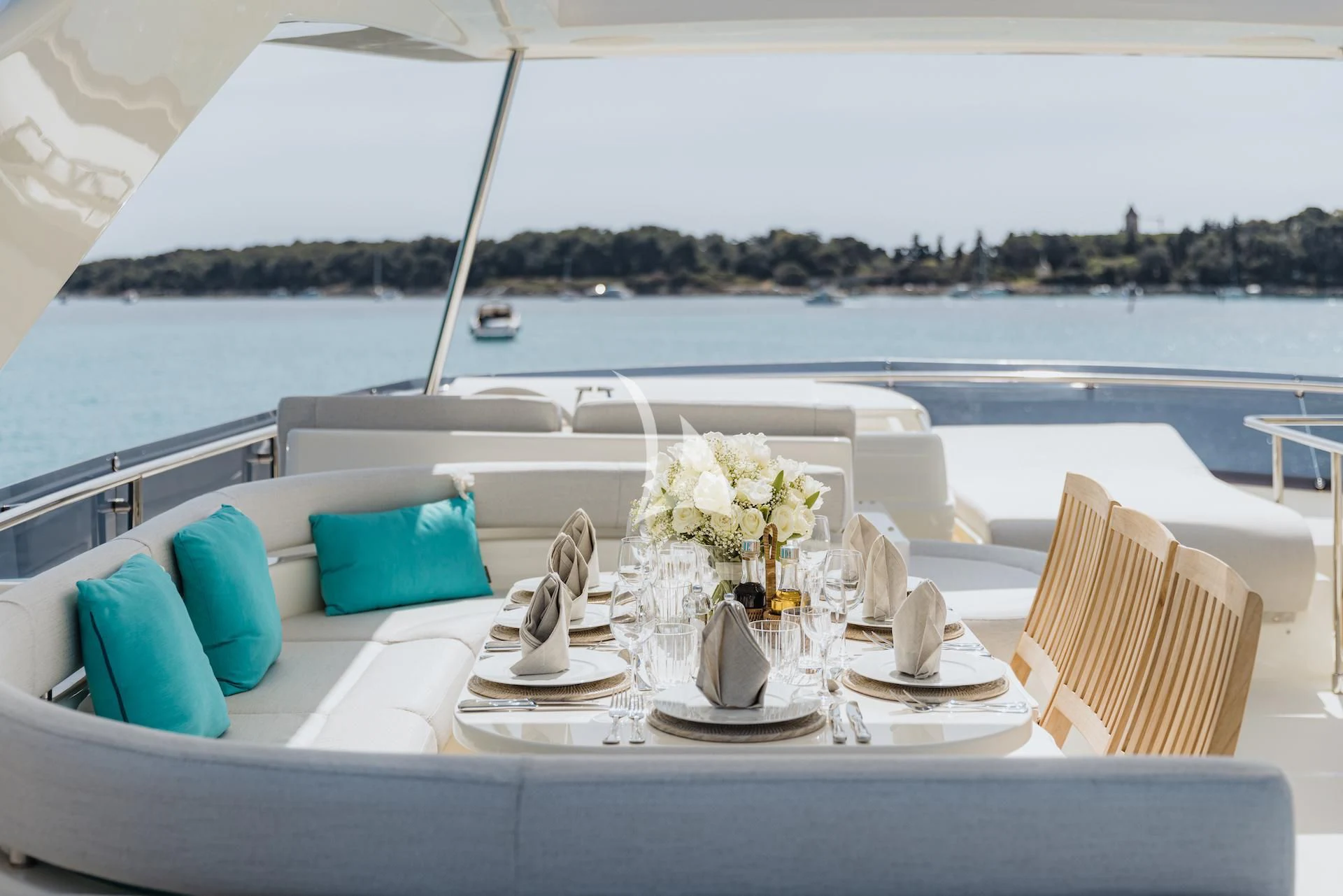 a table with chairs and a large body of water in the background aboard ONYX Yacht for Charter