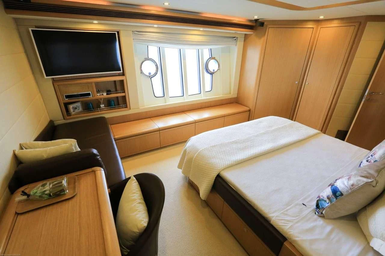 a room with a bed and a television aboard ONYX Yacht for Charter