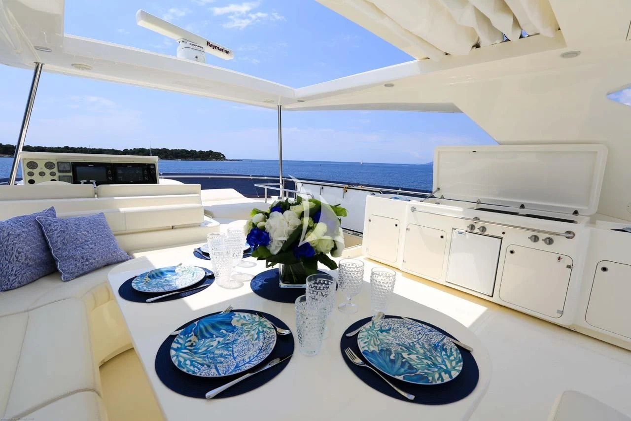 a white kitchen with blue and white plates on a table aboard ONYX Yacht for Charter