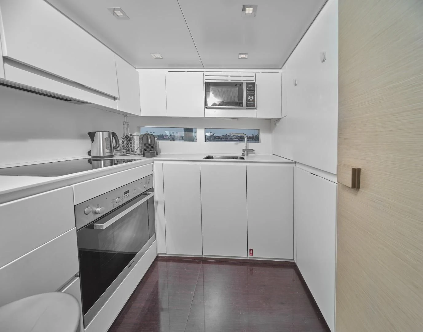 a kitchen with white cabinets aboard AIFOS Yacht for Sale