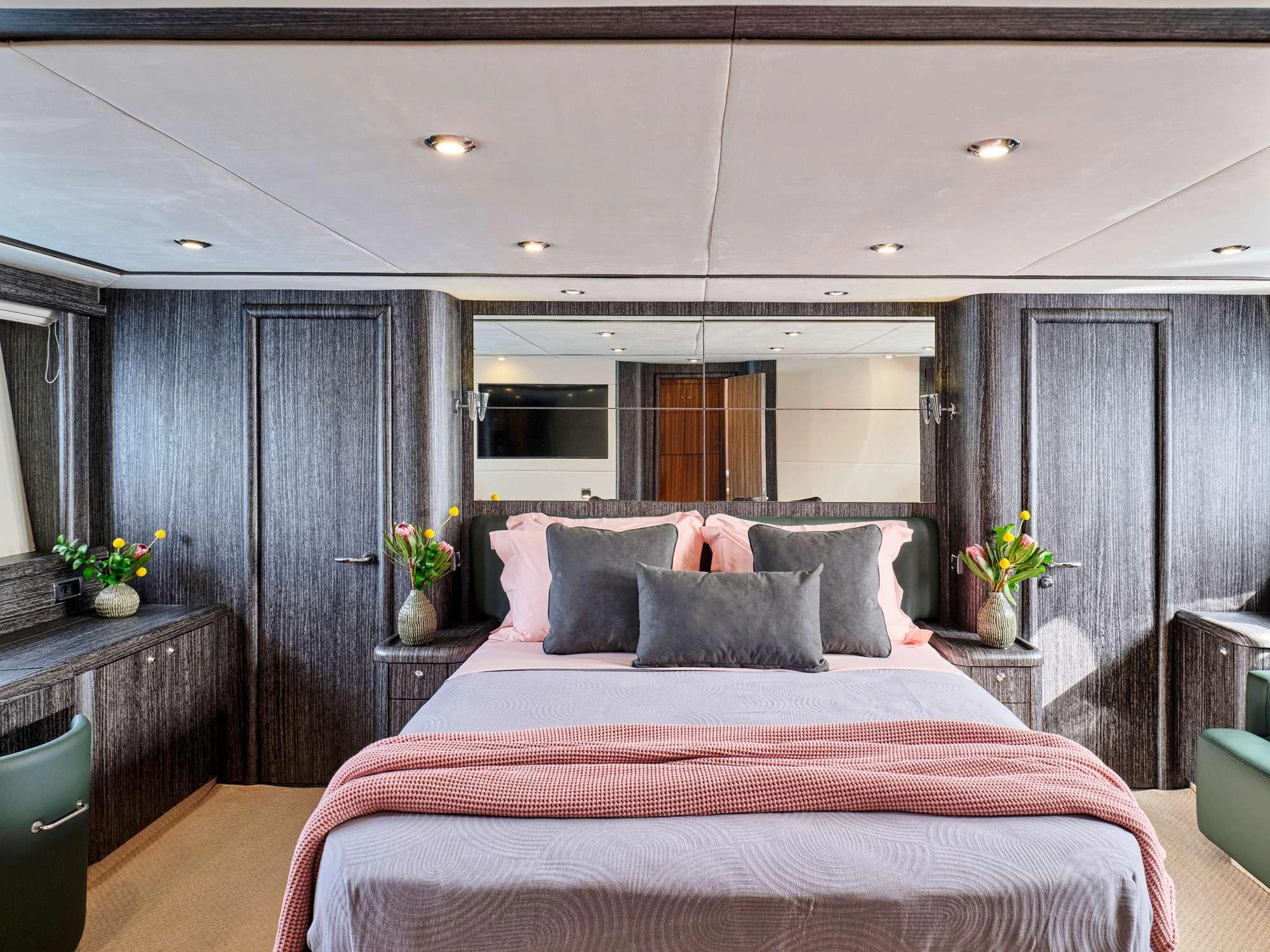 a bed with a pink comforter aboard M FIVE Yacht for Charter