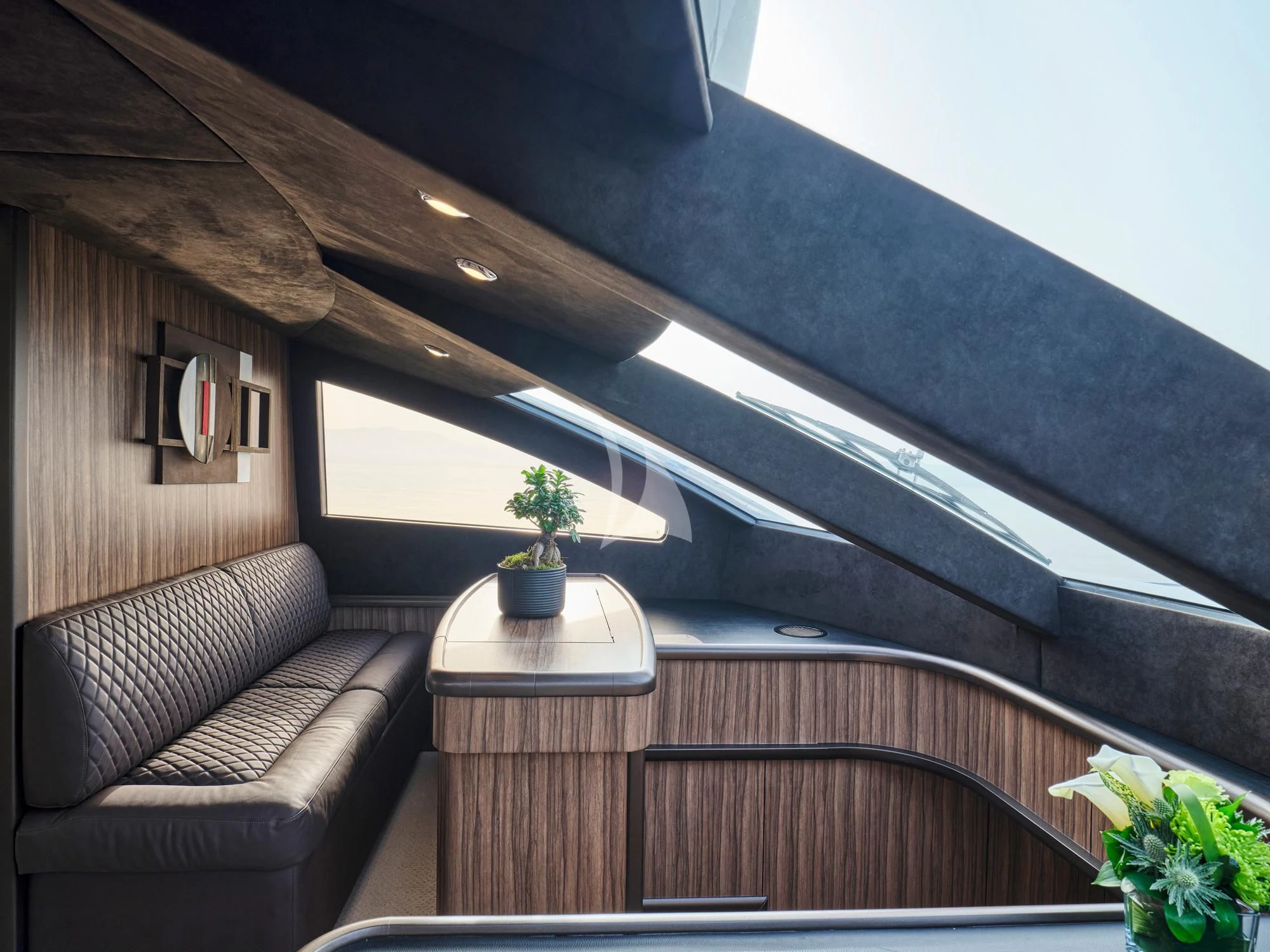a room with a couch and a plant in it aboard M FIVE Yacht for Charter