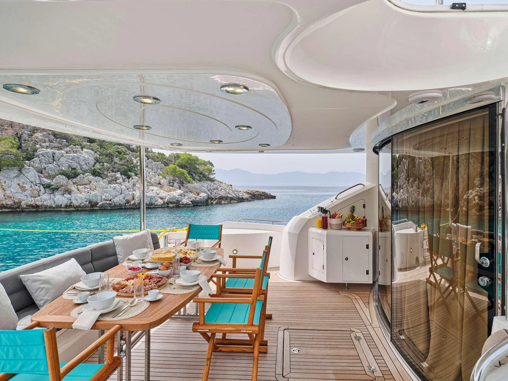 a table and chairs on a deck overlooking a body of water aboard M FIVE Yacht for Charter