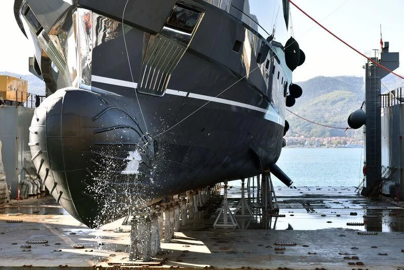 a large military ship docked aboard MY ALMA Yacht for Sale
