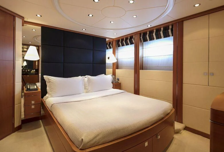 a bedroom with a bed and a desk aboard L'EQUINOX Yacht for Sale