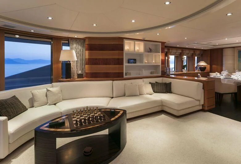 a living room with a large sofa aboard L'EQUINOX Yacht for Sale