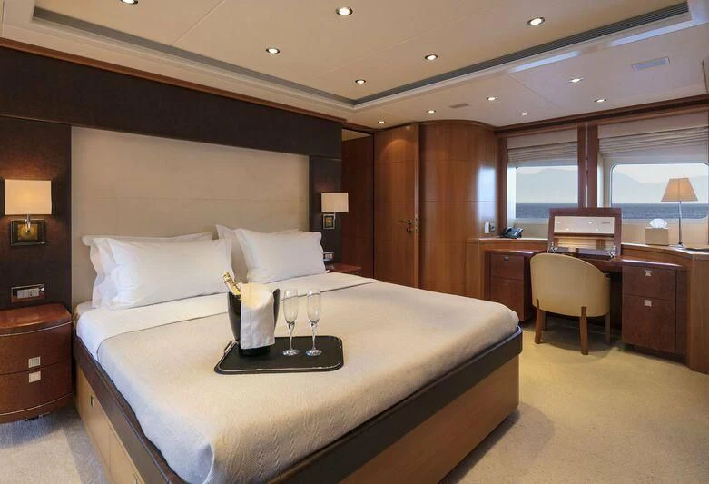 a hotel room with a bed and wine glasses aboard L'EQUINOX Yacht for Sale