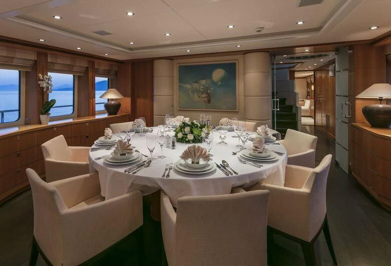 a dining room with white chairs aboard L'EQUINOX Yacht for Sale