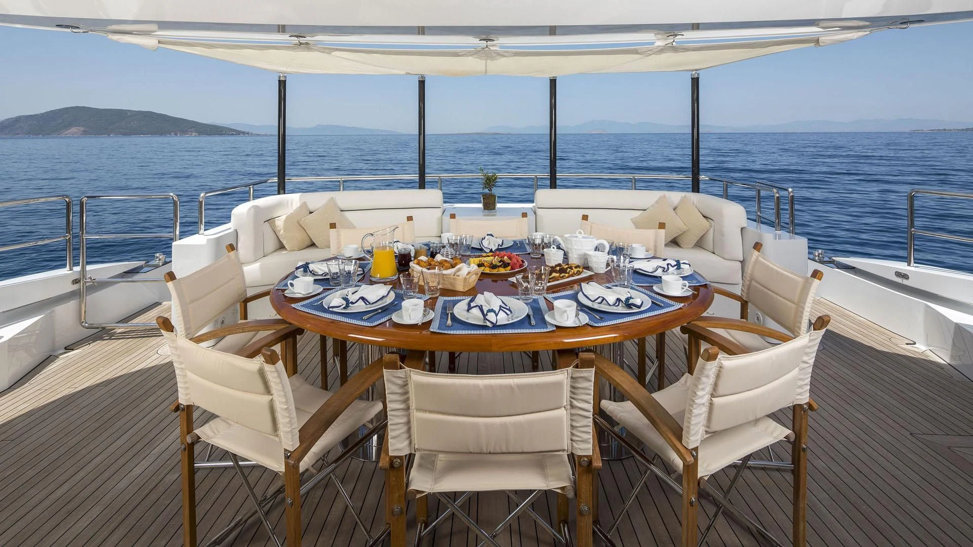 a table set for a meal on a deck overlooking the ocean aboard L'EQUINOX Yacht for Sale