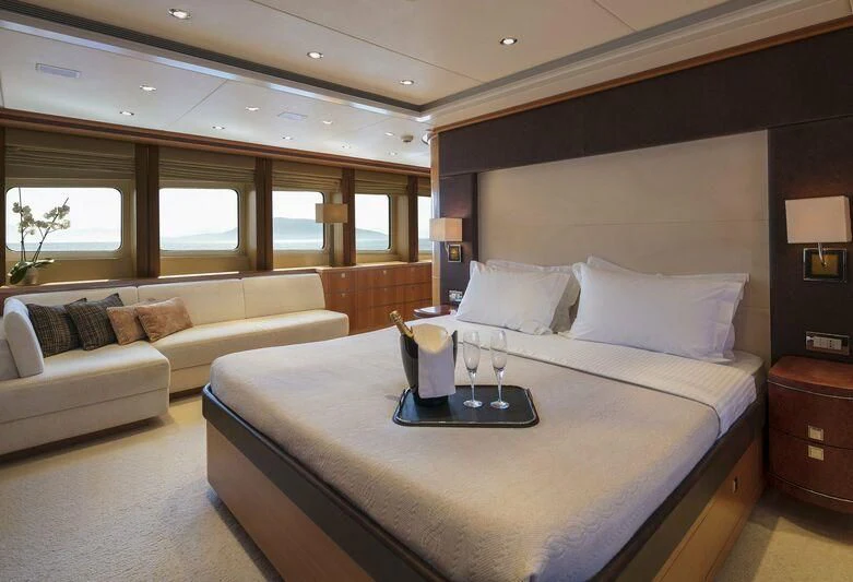 a bed with a white bed spread aboard L'EQUINOX Yacht for Sale