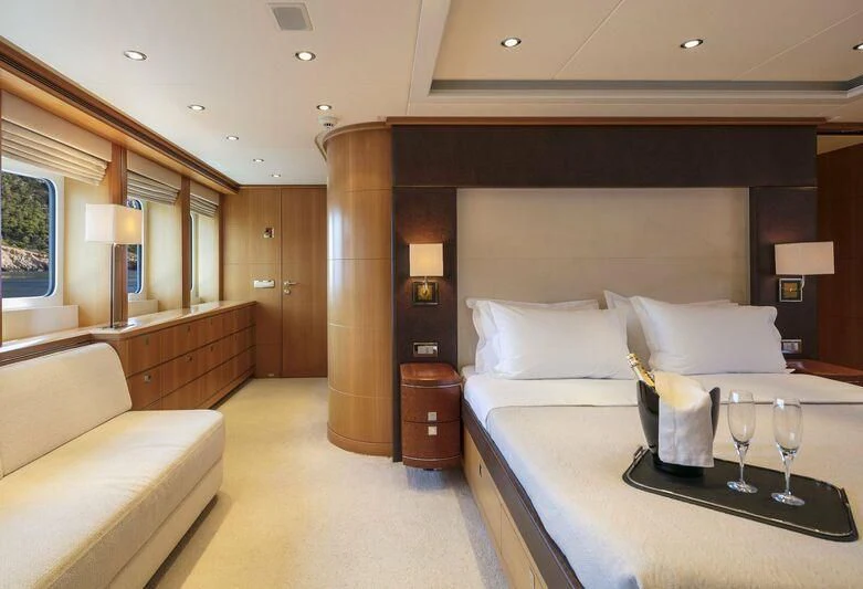 a hotel room with a bed and wine glasses aboard L'EQUINOX Yacht for Sale