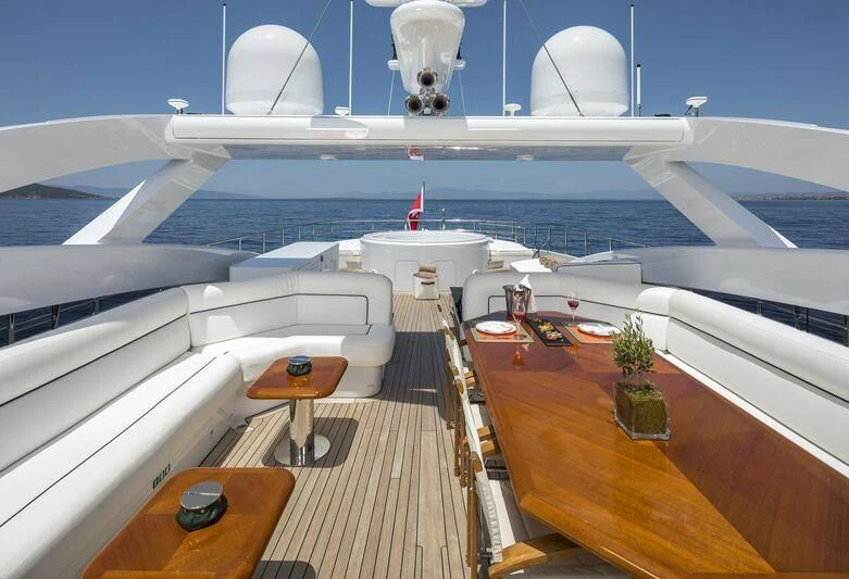 a large white ship with a table and chairs on it aboard L'EQUINOX Yacht for Sale