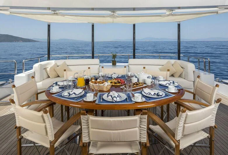 a table set for a meal on a balcony overlooking the ocean aboard L'EQUINOX Yacht for Sale