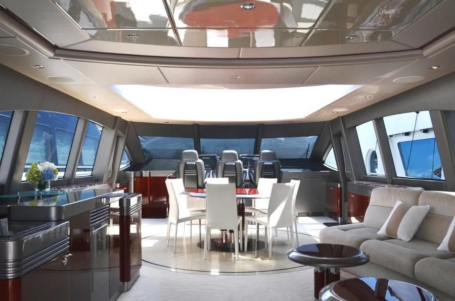 a room with tables and chairs aboard INVICTA Yacht for Sale