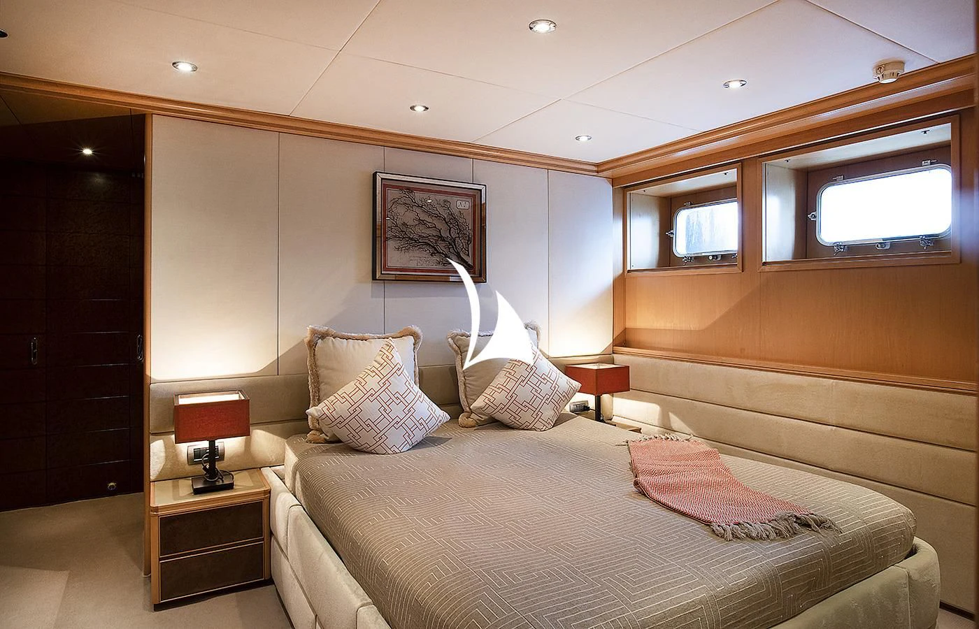 a bed with pillows and a lamp aboard DEEP BLUE II Yacht for Charter