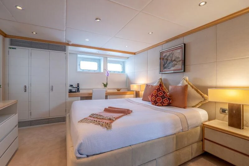 a bedroom with a bed and a desk aboard DEEP BLUE II Yacht for Charter