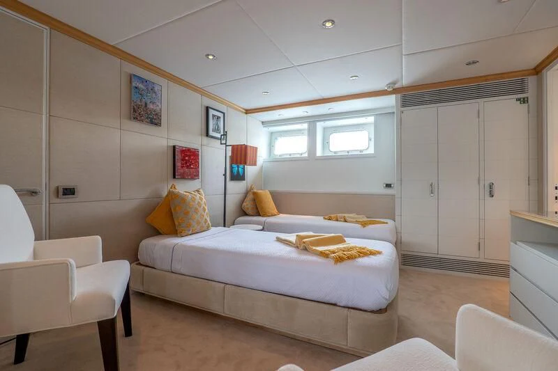 a bedroom with a bed and a chair aboard DEEP BLUE II Yacht for Charter