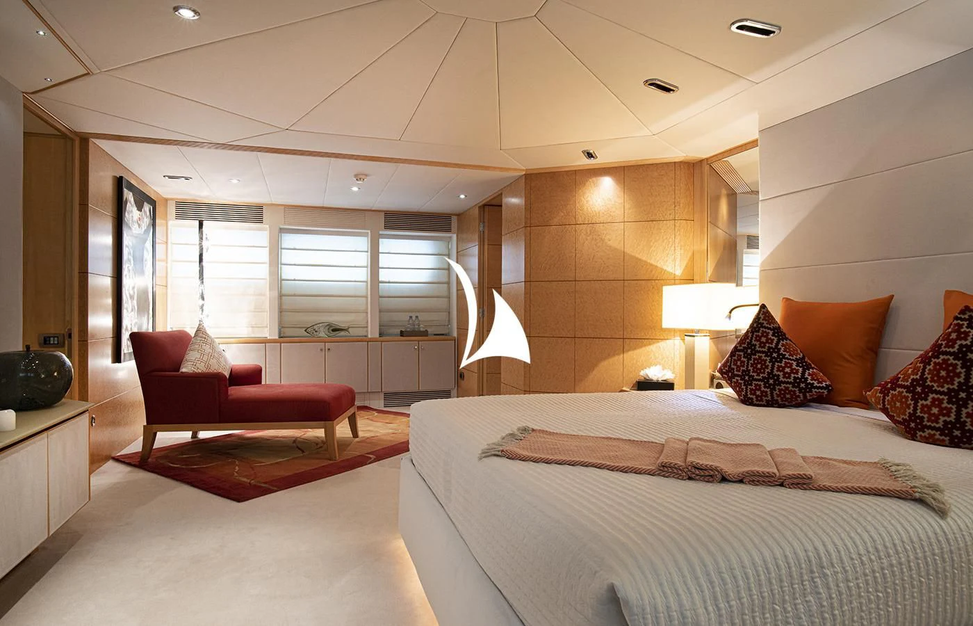 a large bedroom with a bed and a chair aboard DEEP BLUE II Yacht for Charter