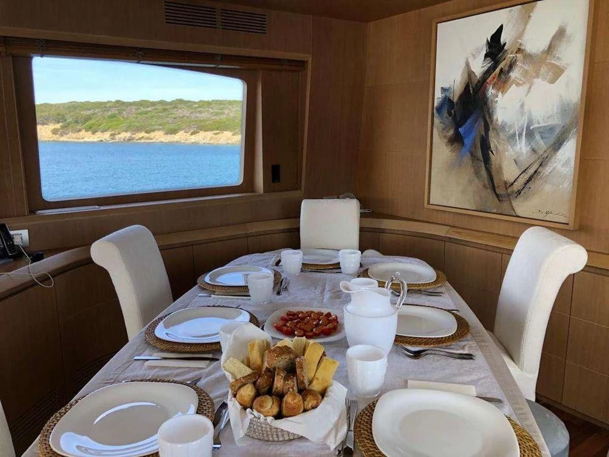 a table with plates and food on it aboard DUBAI Yacht for Sale