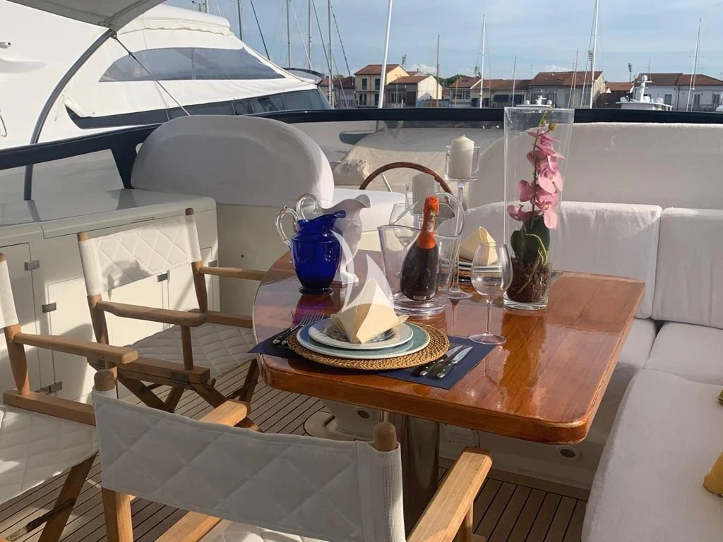 a table with a plate and a vase with flowers on it aboard DUBAI Yacht for Sale