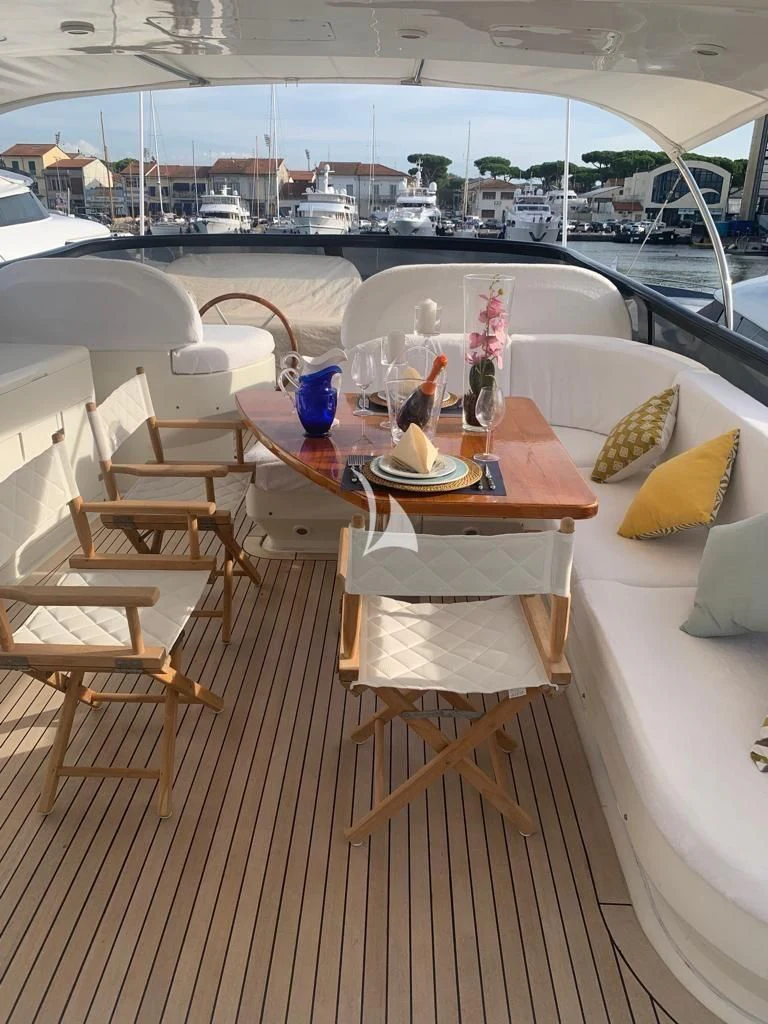 a table with chairs and a view of a city aboard DUBAI Yacht for Sale