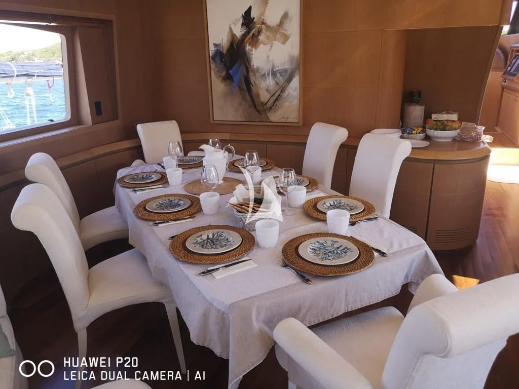 a dining table with plates and chairs aboard DUBAI Yacht for Sale