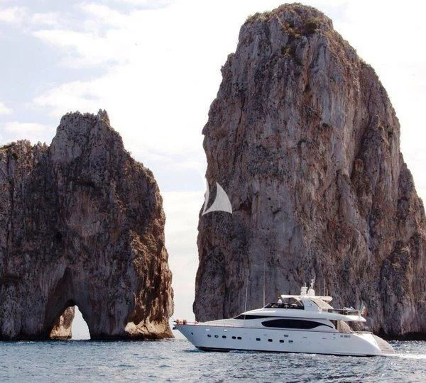 a boat in the water by a large rock formation aboard DUBAI Yacht for Sale