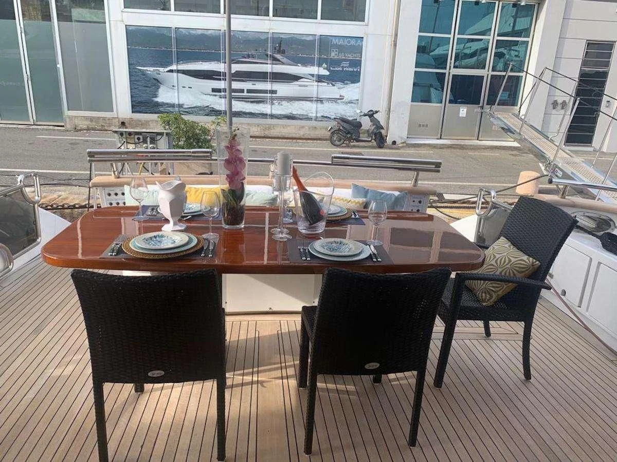 a table with plates and chairs aboard DUBAI Yacht for Sale