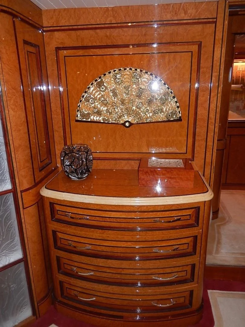 a wood cabinet with a round mirror aboard ATLANTIDE Yacht for Sale