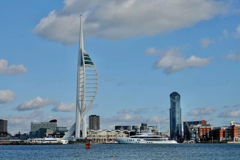 a tall white tower with a boat in the water with Spinnaker Tower in the background aboard AVANTI Yacht for Sale