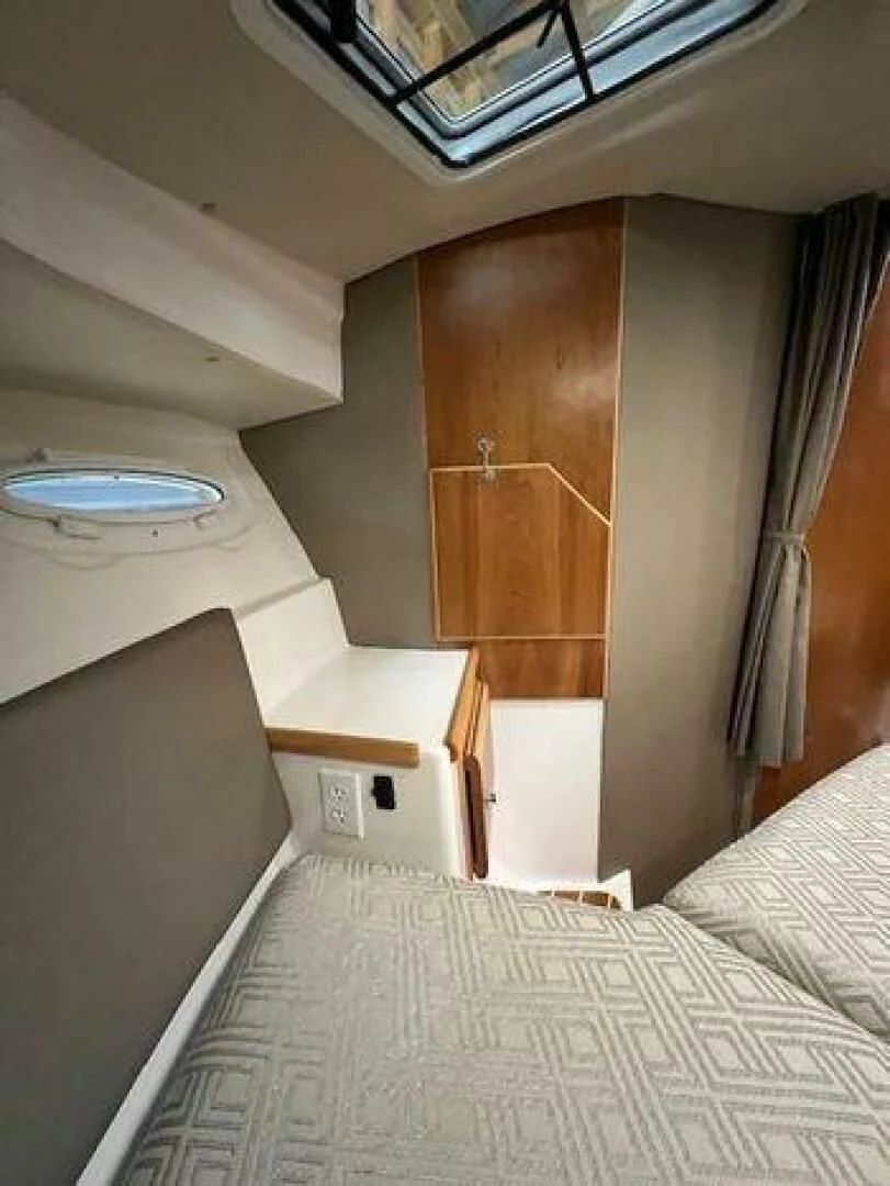 a bed with a white bed spread aboard SKYCHASER Yacht for Sale