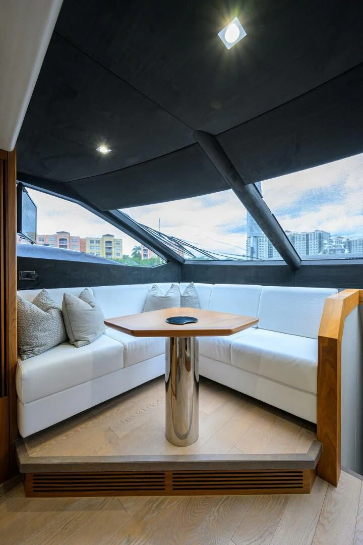 a couch and a table in a room with a window aboard SKYCHASER Yacht for Sale