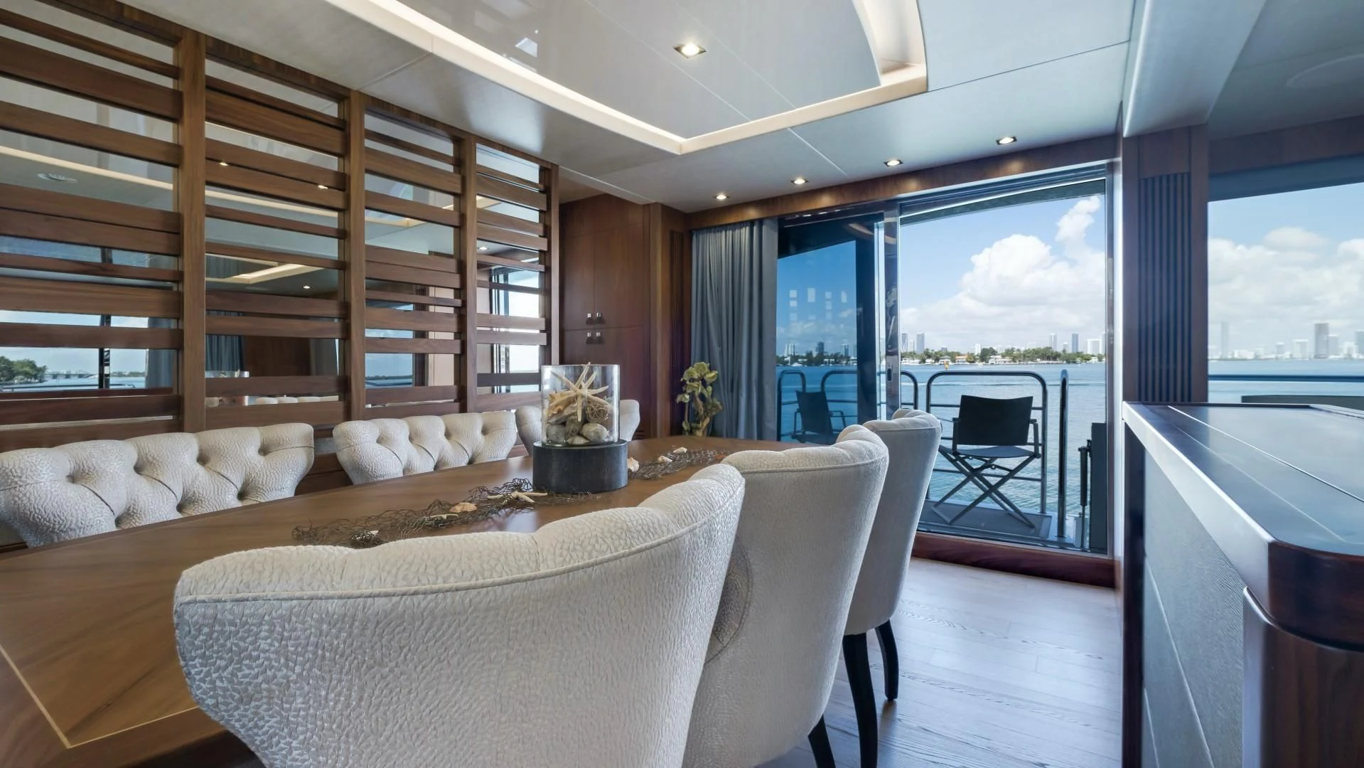 a room with a large window and a table with chairs aboard SKYCHASER Yacht for Sale