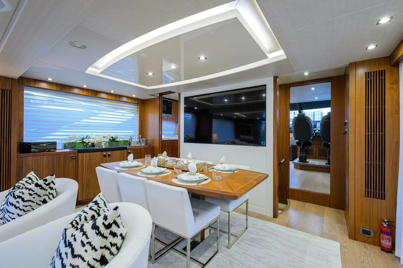 a dining table and chairs in a room with a wood door aboard SKYCHASER Yacht for Sale